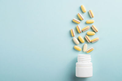 Vitamins and herbal supplements in jars with a green plant.