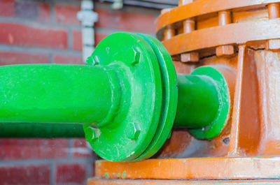 Close-up of water drop on pipe against wall