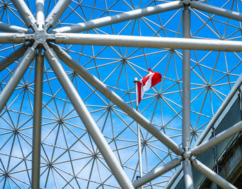 Low angle view of amusement park ride against blue sky