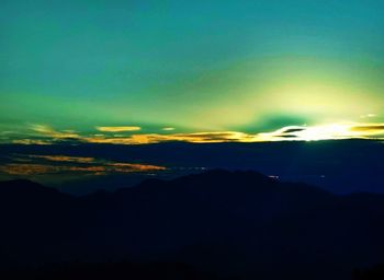 Scenic view of silhouette mountains against dramatic sky