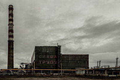 Industrial building against cloudy sky