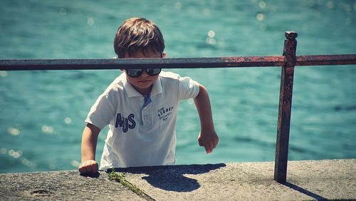 Rear view of boy against sea