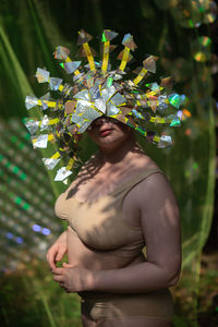 Women in iridescent handmade mask in bikini