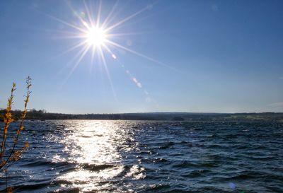 Scenic view of sea against blue sky on sunny day
