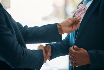 Midsection of business colleagues shaking hands