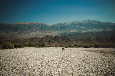 Scenic view of land and mountains against sky