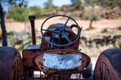 Close-up of old rusty motorcycle on field