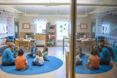 Teacher sitting on floor with children