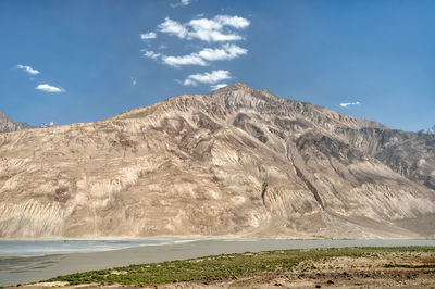 Scenic view of land and mountains against sky