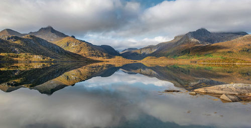 Beautiful mountainous landscape reflected on the water with clouds in the sky - svolvaer in norway