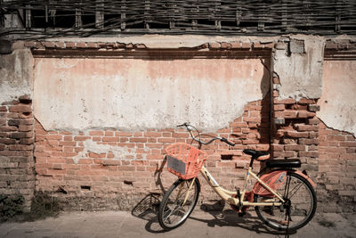 Bicycle parked against wall in old building