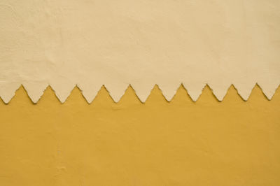 Close-up of simmetric wall pattern with yellow ocre colors