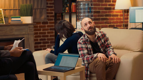 Friends using digital tablet while sitting at home