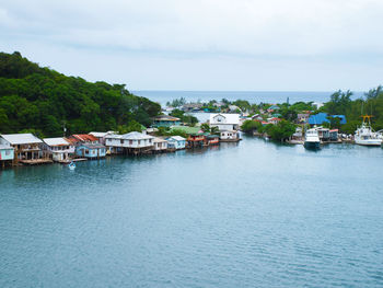 Buildings by sea against sky