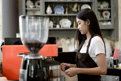 Woman standing by coffee at cafe