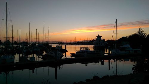 Sailboats in sea at sunset