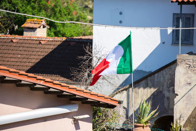 Multi colored flags hanging on roof of building