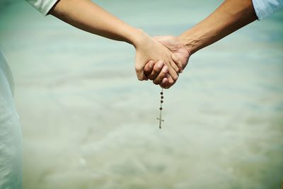 Cropped image of couple holding hands