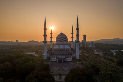 Buildings in city against sky during sunset
