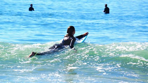 Rear view of woman surfing in sea