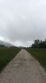 Road amidst field against sky