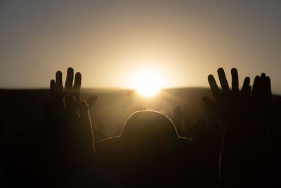 Silhouette people against sky during sunset