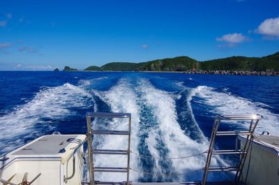 Boat sailing on sea against blue sky