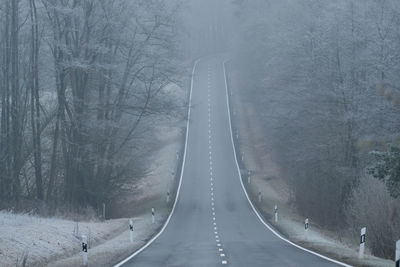 Foggy day empty curve steep countryroad. low visibility. drive slowly and carefully.