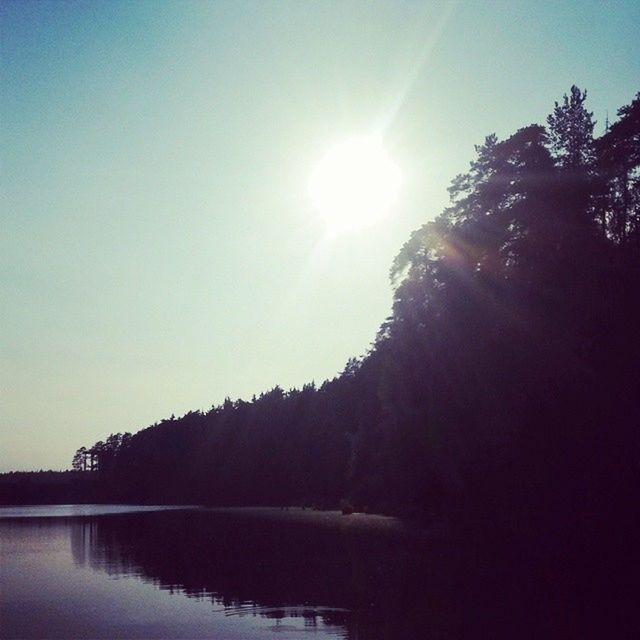 sun, tranquil scene, tranquility, tree, scenics, sunlight, beauty in nature, water, clear sky, sunbeam, snow, winter, lake, nature, reflection, mountain, silhouette, cold temperature, lens flare, waterfront