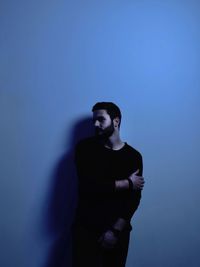 Young man standing against wall