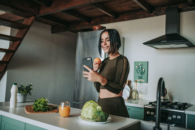 Full length of woman holding mobile phone