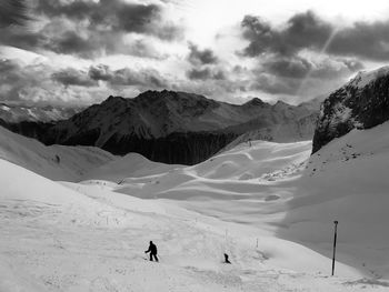 People on snowcapped mountain against sky