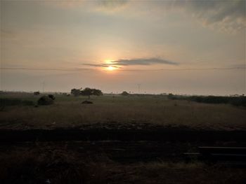 Scenic view of field against sky during sunset