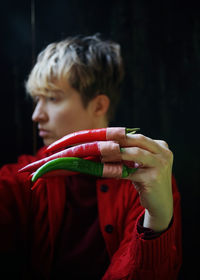 Portrait of man holding red chili peppers
