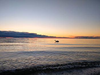 Scenic view of sea against clear sky at sunset