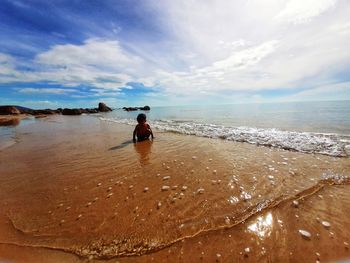 Boy crouching at beach