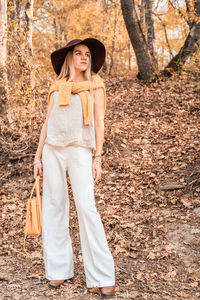 Midsection of woman standing by tree in forest