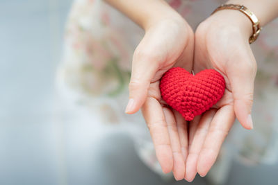 Midsection of woman holding red heart