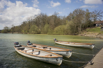 Boats moored on canal against sky