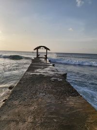 Pier over sea against sky during sunset