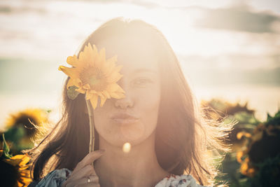 Close-up of woman with pink flower