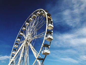 Low angle view of ferris wheel against blue sky