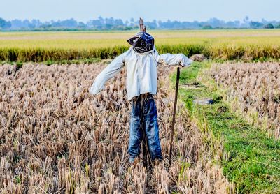 Scarecrow on field against sky