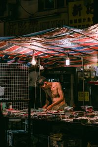 Man working at market stall at night