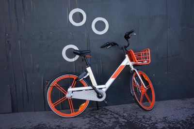 Bicycle parked on street against wall