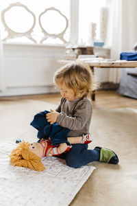 Girl sitting on toy at home