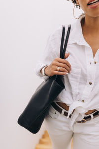 Black woman dressed in white carrying a bag