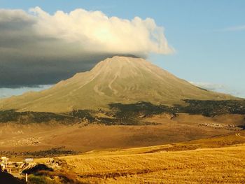 Scenic view of mountains against cloudy sky