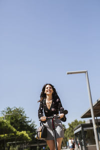 Young woman with e-scooter in the city