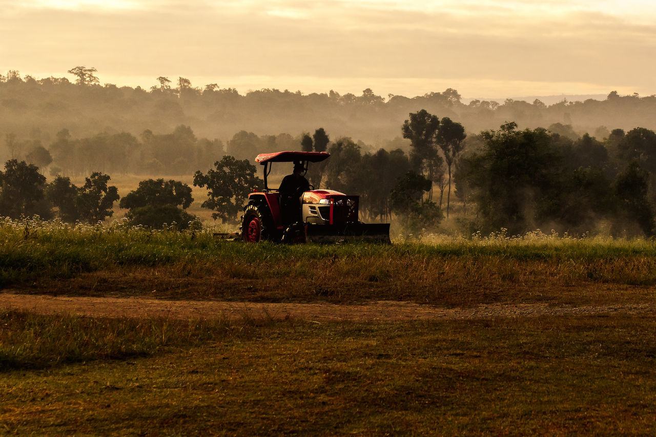 ABANDONED TRACTOR ON FIELD AGAINST SKY